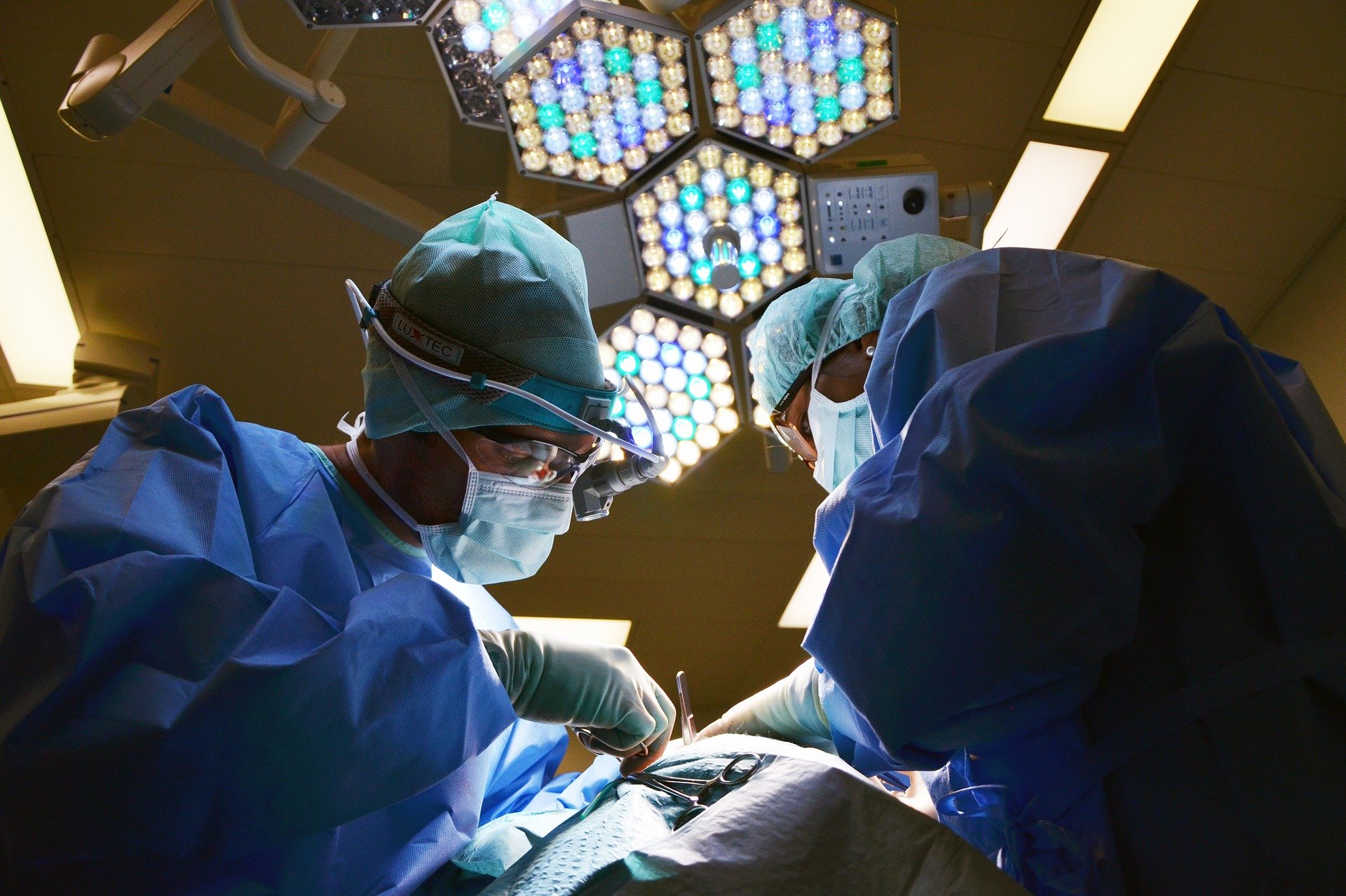 Jednorazowa odzież medyczna, a w tym fartuchy, maseczki oraz czepki chirurgiczne, to niezbędne indywidualne środki ochrony na sali operacyjnej (Źródło: pixabay.com, Autor: marionbrun)